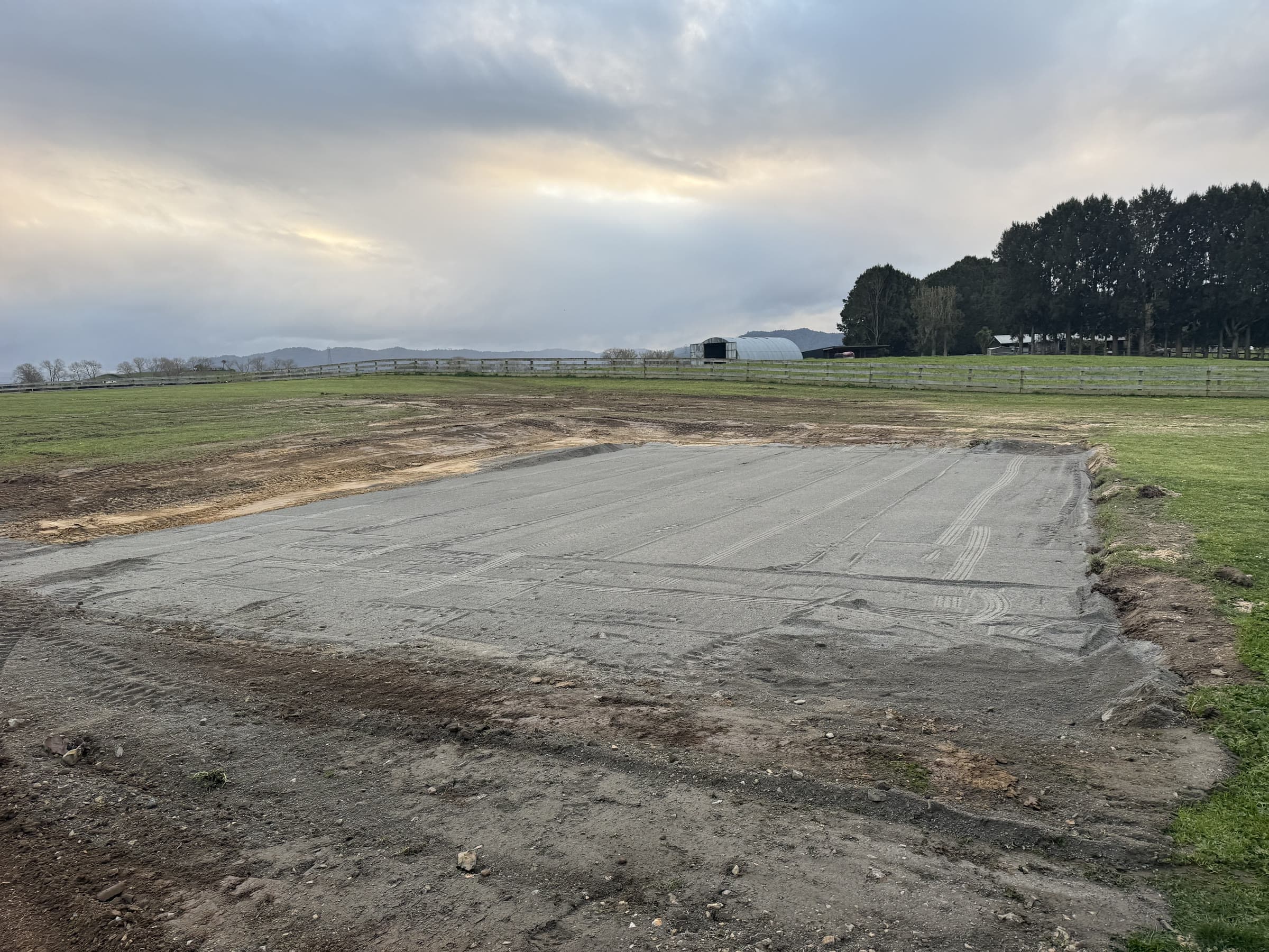 Compacted building pad formed in a Waikato paddock, ranges in the distance